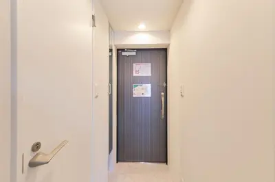 a hallway with a door with a sign on it at Ruygo Setagaya by Tranova in Tokyo
