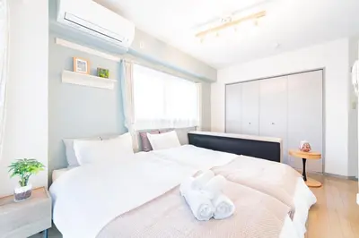 a bedroom with a bed with two white towels on it at FRt\u6075\u6bd4\u5bff2\u4e01\u76ee306 in Tokyo