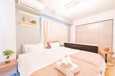 a bedroom with a large white bed with two white towels at FRt\u6075\u6bd4\u5bff2\u4e01\u76ee306 in Tokyo
