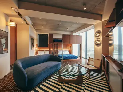 a living room with a blue couch and a bed at illi Amu Shimokitazawa in Tokyo