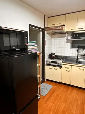 a kitchen with a black refrigerator and a stove at ZYZSumiyoshichō 2K SJ0254 in Tokyo