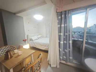 a bedroom with a bed and a table and a window at ZYZHigashinippori 1DK AK0255 in Tokyo