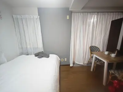 a bedroom with a bed and a table and a window at ZYZHigashinippori 1DK AK0255 in Tokyo