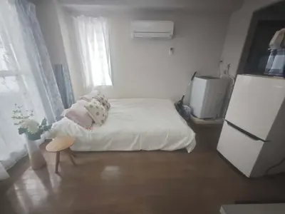 a small bedroom with a bed and a refrigerator at ZYZHigashinippori 1DK AK0255 in Tokyo