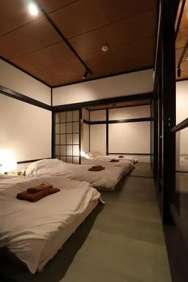 a row of beds are lined up in a room at \u30a2\u30f3\u30c9\u30b9\u30c6\u30a4\u5343\u4f4f\u5bff\u753a in Tokyo