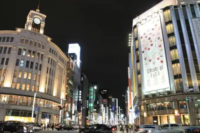 a busy city street at night with a clock tower at Y's INN 北砂 101T in Tokyo