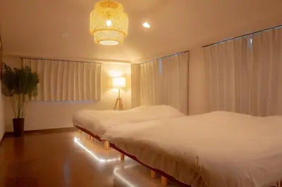 a bedroom with two beds and a chandelier at Sky Tree View Asakusa in Tokyo