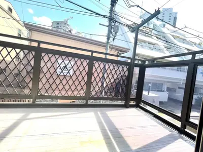 a balcony with a fence with a view of a building at \u6771\u65b0\u5bbf\u30de\u30f3\u30b9\u30ea\u30fc\u30cf\u30a6\u30b9 in Tokyo