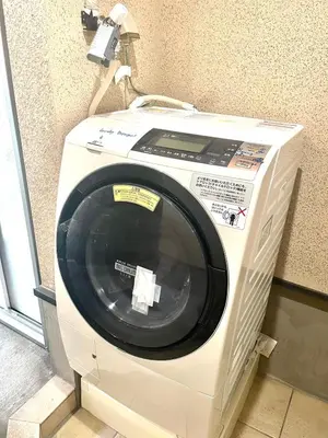 a washing machine with a phone on top of it at \u6771\u65b0\u5bbf\u30de\u30f3\u30b9\u30ea\u30fc\u30cf\u30a6\u30b9 in Tokyo