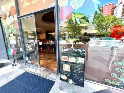 a restaurant entrance with a sign in the window at \u6771\u65b0\u5bbf\u30de\u30f3\u30b9\u30ea\u30fc\u30cf\u30a6\u30b9 in Tokyo