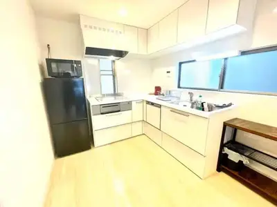 a kitchen with white cabinets and a black refrigerator at \u6771\u65b0\u5bbf\u30de\u30f3\u30b9\u30ea\u30fc\u30cf\u30a6\u30b9 in Tokyo