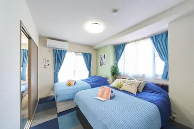 a bedroom with two beds with blue sheets at Shamrock Aoto 201 Cozy Tokyo Stay Near Station Airport Disney Access in Tokyo