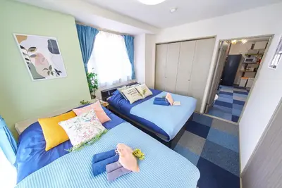 a small room with two beds and a hallway at Shamrock Aoto 201 Cozy Tokyo Stay Near Station Airport Disney Access in Tokyo