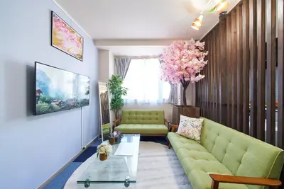 a living room with a green couch and a table at Shamrock Aoto 201 Cozy Tokyo Stay Near Station Airport Disney Access in Tokyo