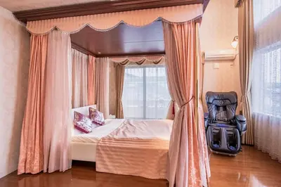a bedroom with a bed and a chair in front of a window at Sugamo Aqua Palace -\u6700\u592710\u540d\u6c60\u888b\u30a8\u30ea\u30a2220\u5e73\u7c73\u306e\u8c6a\u90b8- in Tokyo