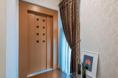 a hallway with a door and a window with a painting at Sugamo Aqua Palace -\u6700\u592710\u540d\u6c60\u888b\u30a8\u30ea\u30a2220\u5e73\u7c73\u306e\u8c6a\u90b8- in Tokyo