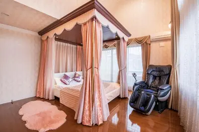 a bedroom with a bed and a chair in it at Sugamo Aqua Palace -\u6700\u592710\u540d\u6c60\u888b\u30a8\u30ea\u30a2220\u5e73\u7c73\u306e\u8c6a\u90b8- in Tokyo