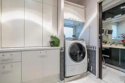 a washing machine in a kitchen with white cabinets at Sugamo Aqua Palace -\u6700\u592710\u540d\u6c60\u888b\u30a8\u30ea\u30a2220\u5e73\u7c73\u306e\u8c6a\u90b8- in Tokyo