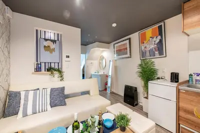 a living room with a white couch and a kitchen at Bibarudy Shinagawa -\u54c1\u5ddd\u30a8\u30ea\u30a2\u99c5\u524d1\u52068\u540d \u7fbd\u7530\u7a7a\u6e2f25\u5206- in Tokyo