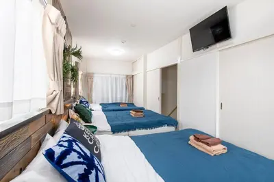 a group of three beds in a room at Bibarudy Shinagawa -\u54c1\u5ddd\u30a8\u30ea\u30a2\u99c5\u524d1\u52068\u540d \u7fbd\u7530\u7a7a\u6e2f25\u5206- in Tokyo
