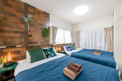 two beds in a room with blue and white at Bibarudy Shinagawa -\u54c1\u5ddd\u30a8\u30ea\u30a2\u99c5\u524d1\u52068\u540d \u7fbd\u7530\u7a7a\u6e2f25\u5206- in Tokyo