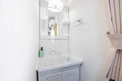 a white bathroom with a sink and a mirror at Bibarudy Shinagawa -\u54c1\u5ddd\u30a8\u30ea\u30a2\u99c5\u524d1\u52068\u540d \u7fbd\u7530\u7a7a\u6e2f25\u5206- in Tokyo