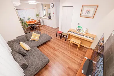 a living room with a couch and a piano at kamiikebukuro house 4LDK free wifi free parking in Tokyo