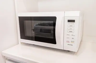 a white microwave oven sitting on a white shelf at kamiikebukuro house 4LDK free wifi free parking in Tokyo