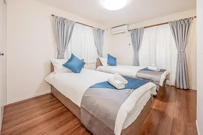 a bedroom with two beds with blue pillows at kamiikebukuro house 4LDK free wifi free parking in Tokyo