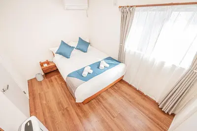 a bedroom with a bed with blue pillows and a window at kamiikebukuro house 4LDK free wifi free parking in Tokyo