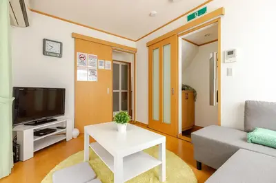 a living room with a couch and a tv and a table at akl\u6771\u745e\u6c5f3\u4e01\u76ee in Tokyo