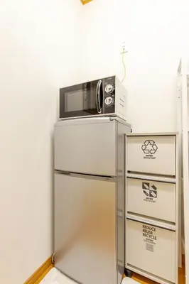 a microwave sitting on top of a refrigerator at akl\u6771\u745e\u6c5f3\u4e01\u76ee in Tokyo