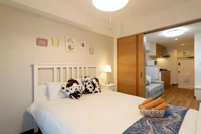 a bedroom with a large white bed with pillows at N102 NEW OPEN IKEBUKURO FREE WiFi MAX7GUESTS in Tokyo