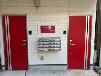 two red doors on the side of a building at \u5922\u306e\u5bbf \u7ffc 132t in Tokyo