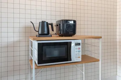 a microwave on a shelf with two appliances on it at \u8429\u5c3e\u30d3\u30eb\u56db\u968e\u4e94\u968e in Tokyo