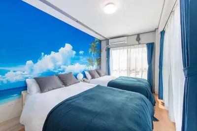 a bedroom with two beds and a blue sky and clouds at \u8429\u5c3e\u30d3\u30eb\u56db\u968e\u4e94\u968e in Tokyo