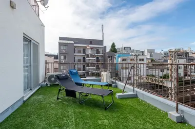 a balcony with a bench and a chair on the grass at \u8429\u5c3e\u30d3\u30eb\u56db\u968e\u4e94\u968e in Tokyo