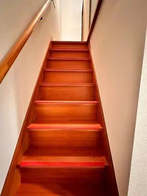 a stair case with wooden steps with red and orange at \u5317\u5343\u4f4f\u306e\u4e00\u8ed2\u5bb6\uff4b3 in Tokyo