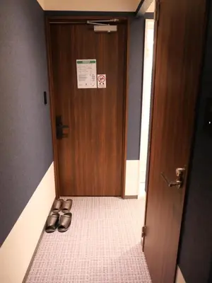 a pair of shoes sitting in front of a door at ForYou Honancho \u65b9\u5357\u753a in Tokyo