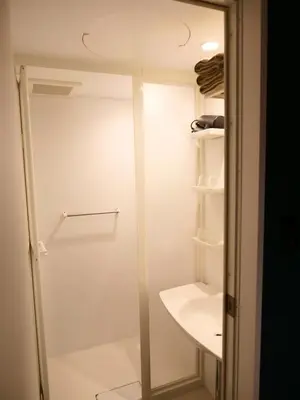 a shower in a bathroom with a glass door at ForYou Honancho \u65b9\u5357\u753a in Tokyo