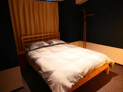 a bedroom with a bed with a white comforter at ForYou Honancho \u65b9\u5357\u753a in Tokyo