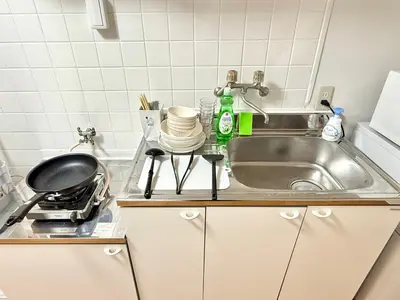 a kitchen counter with a sink and a stove at Shinjuku Waseda home4 in Tokyo