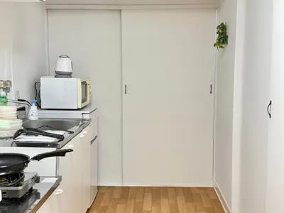 a white kitchen with a stove and a microwave at Shinjuku Waseda home4 in Tokyo