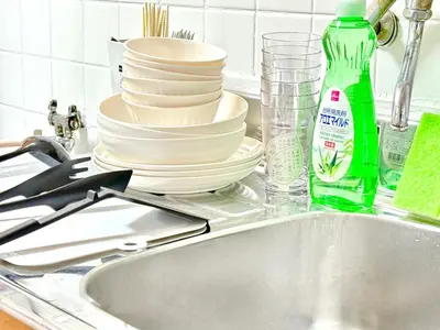 a pile of dishes sitting on a kitchen sink at Shinjuku Waseda home4 in Tokyo
