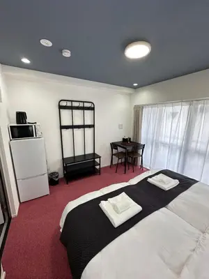 a bedroom with a large bed and a table at \u798f\u30db\u30c6\u30eb401 in Tokyo