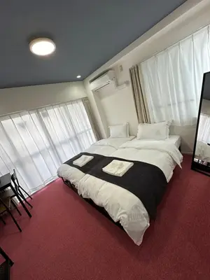 a large bed in a room with windows at \u798f\u30db\u30c6\u30eb401 in Tokyo