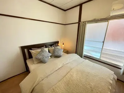 a bedroom with a large bed with a window at \u548c\u98a8\u5c0f\u7b51\u3068\u4eac\u753a\u5c4b in Tokyo