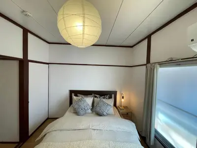a bedroom with a bed and a chandelier at \u548c\u98a8\u5c0f\u7b51\u3068\u4eac\u753a\u5c4b in Tokyo