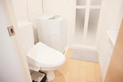 a white bathroom with a toilet and a sink at Mi-HOTEL KOMAGOME in Tokyo