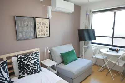a living room with a bed and a chair and a table at Mi-HOTEL KOMAGOME in Tokyo